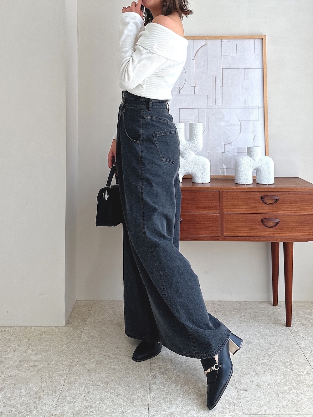 ホワイト系のニット/セーター、ブラック系のデニムパンツ、ブラック系のローファーを着用したレディースの夏コーディネートの2枚目の写真