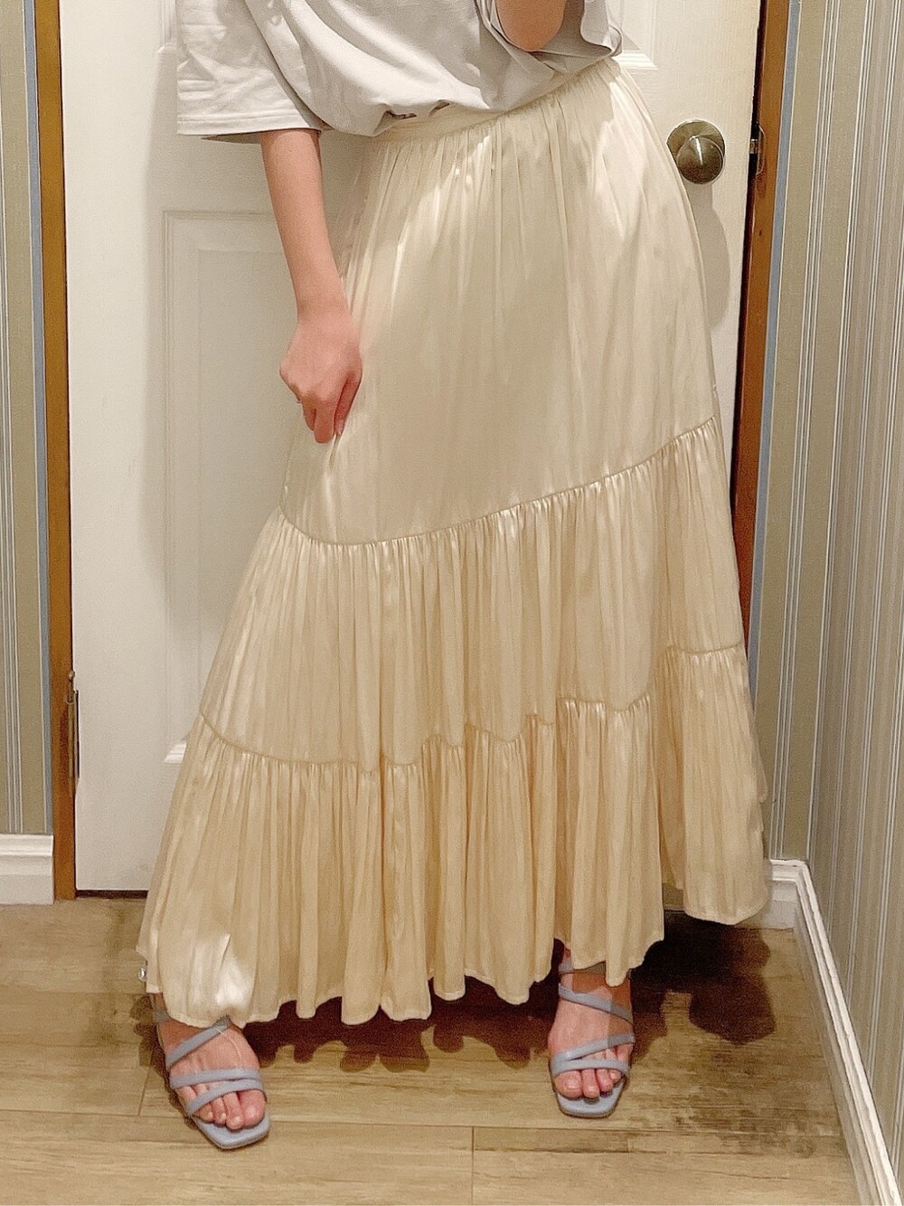 ホワイト系のスカート、ブルー系のサンダル、グレー系のTシャツ/カットソーを着用したレディースの春コーディネートの6枚目の写真