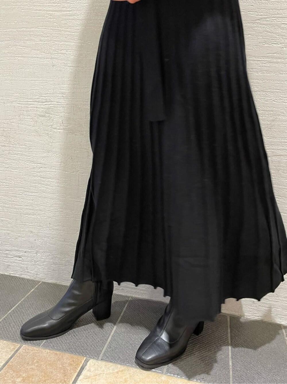 ブラック系のブルゾン、ブラック系のブーツ、ブラック系のワンピースを着用したレディースの秋コーディネートの10枚目の写真