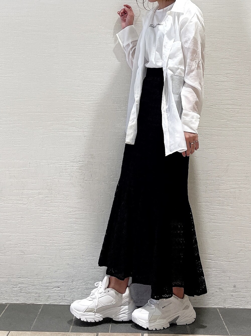 ブラック系のスカート、ホワイト系のスニーカー、ホワイト系のシャツ/ブラウスを着用したレディースの春コーディネートの8枚目の写真