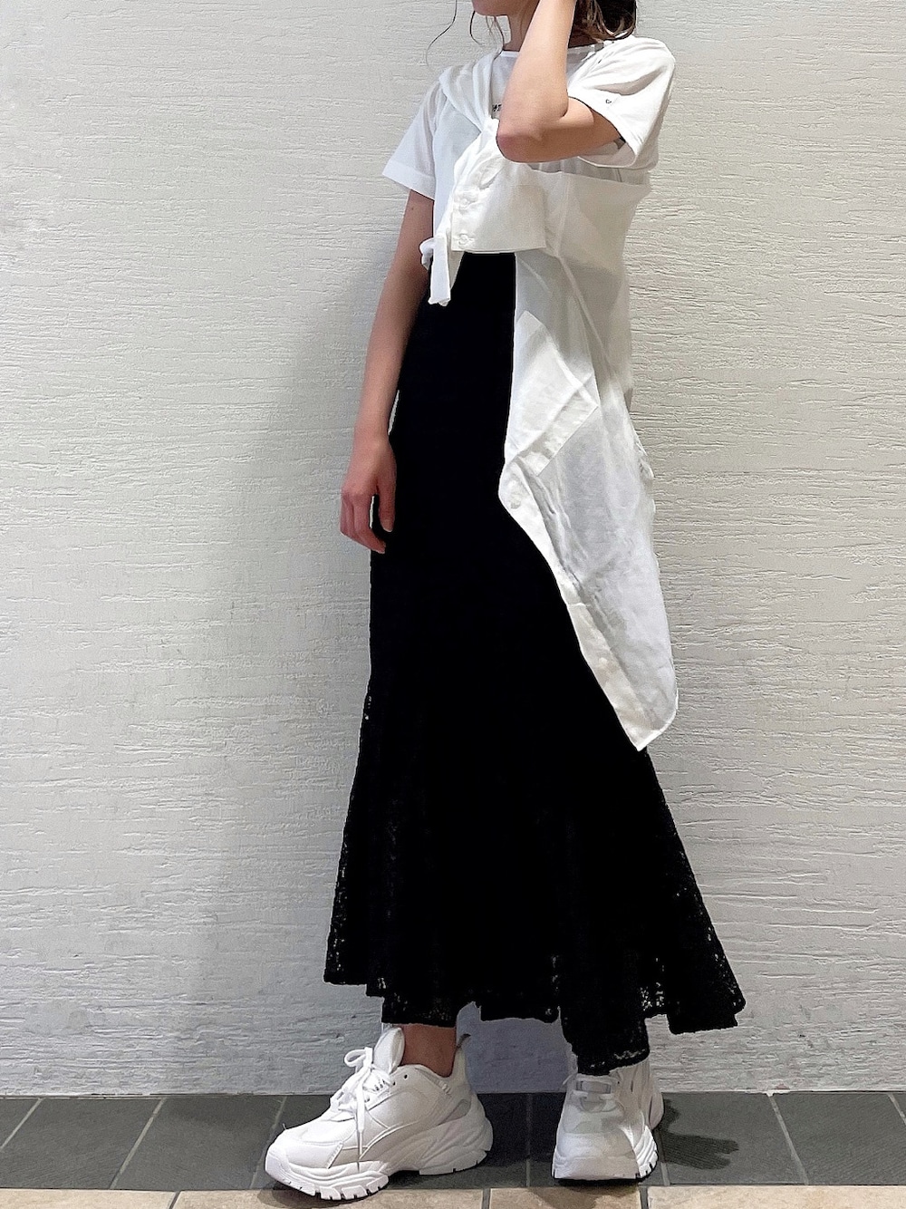 ブラック系のスカート、ホワイト系のスニーカー、ホワイト系のシャツ/ブラウスを着用したレディースの春コーディネートの5枚目の写真