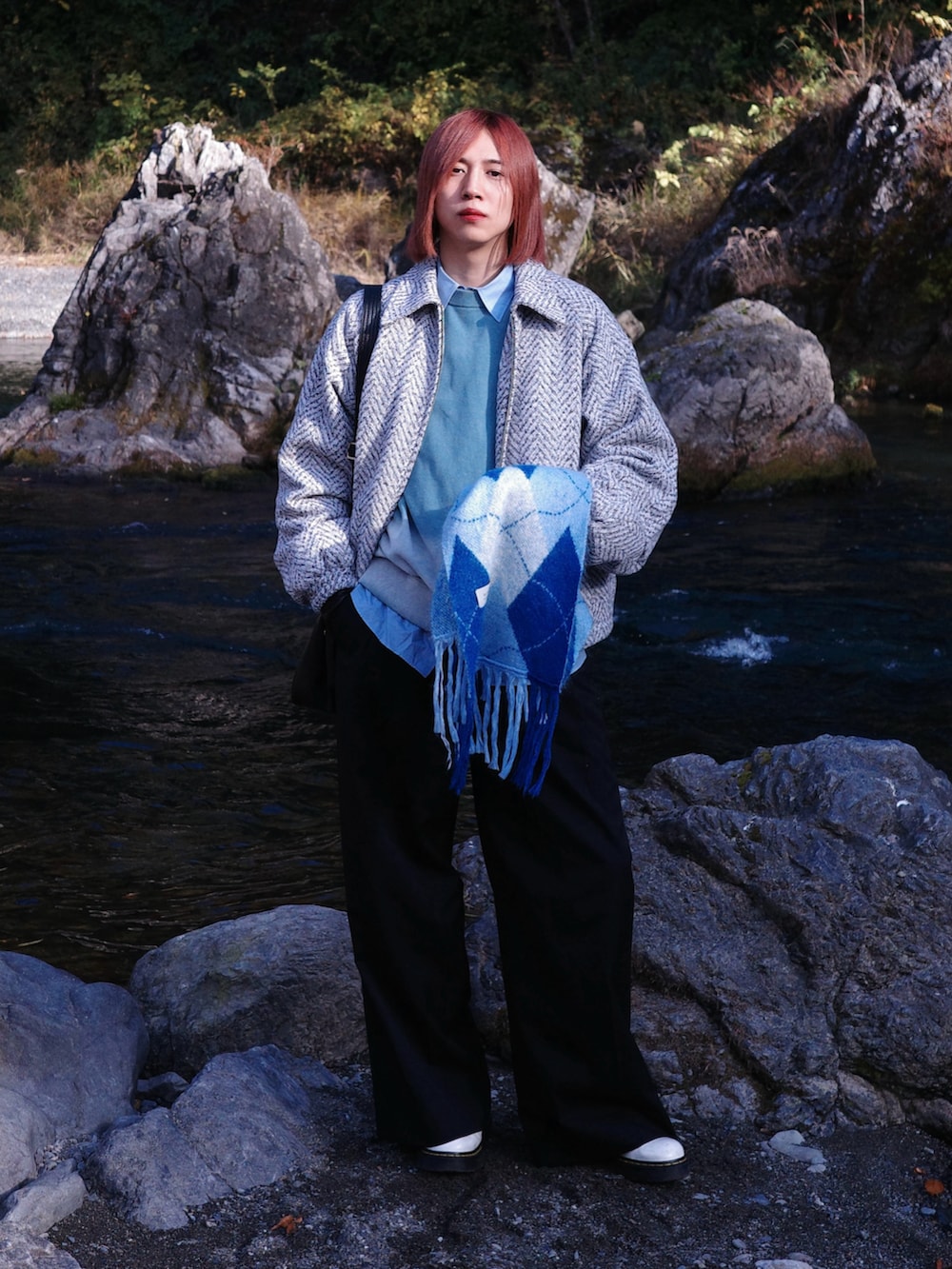 ホワイト系のブルゾン、ブルー系のニット/セーター、ブラック系のスラックスを着用したメンズの冬コーディネートの2枚目の写真