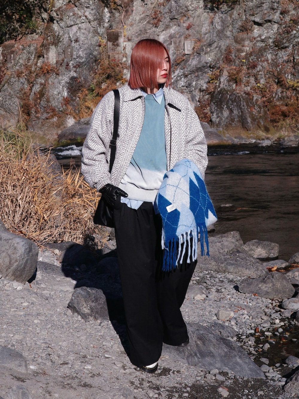 ホワイト系のブルゾン、ブルー系のニット/セーター、ブラック系のスラックスを着用したメンズの冬コーディネートの3枚目の写真