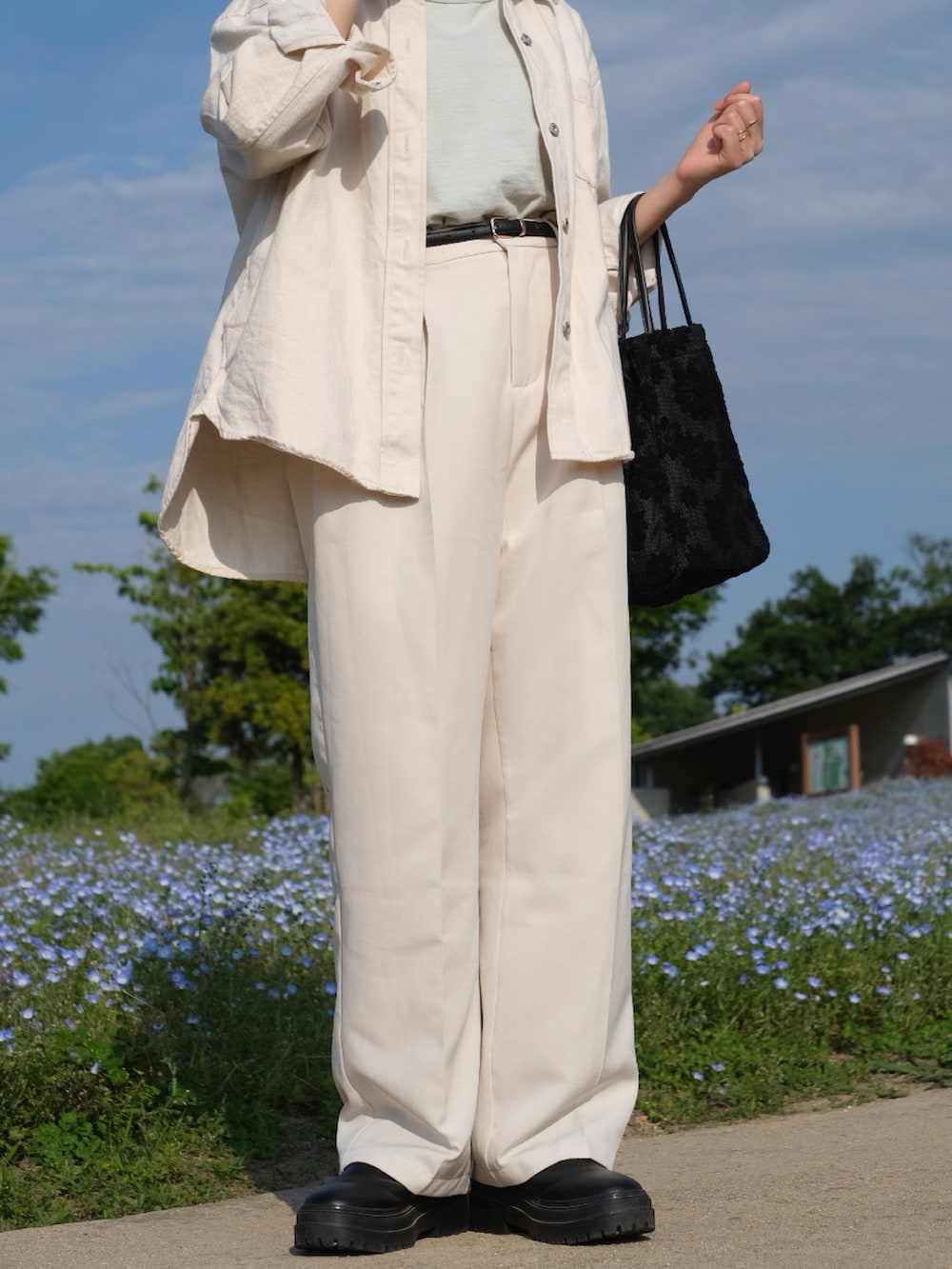 ホワイト系のシャツ/ブラウス、グリーン系のタンクトップ、ホワイト系のスラックスを着用したレディースの春コーディネートの2枚目の写真