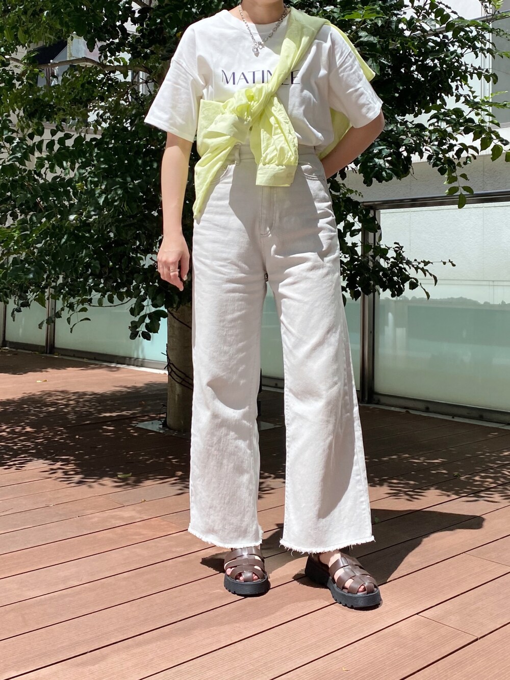 ブラウン系のサンダル、ベージュ系のその他パンツ、ホワイト系のTシャツ/カットソーを着用したレディースの夏コーディネートの2枚目の写真