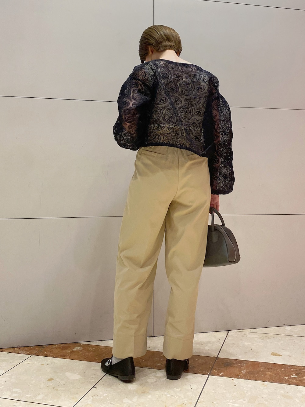 ブラック系のバレエシューズ、グレー系のバッグ、ベージュ系のチノパンツを着用したレディースの春コーディネートの2枚目の写真