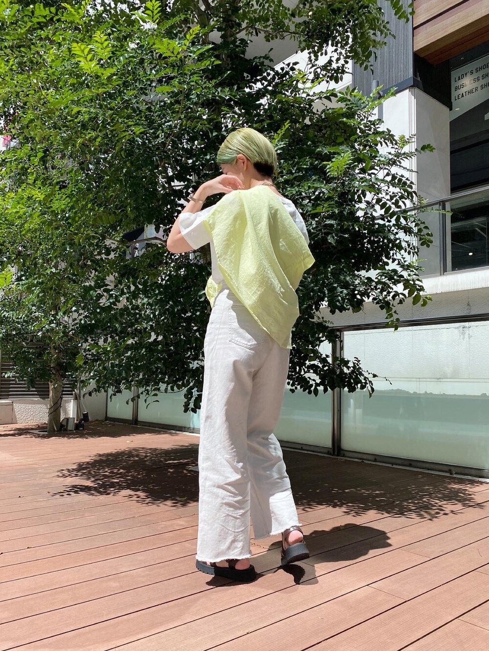 ブラウン系のサンダル、ベージュ系のその他パンツ、ホワイト系のTシャツ/カットソーを着用したレディースの夏コーディネートの3枚目の写真