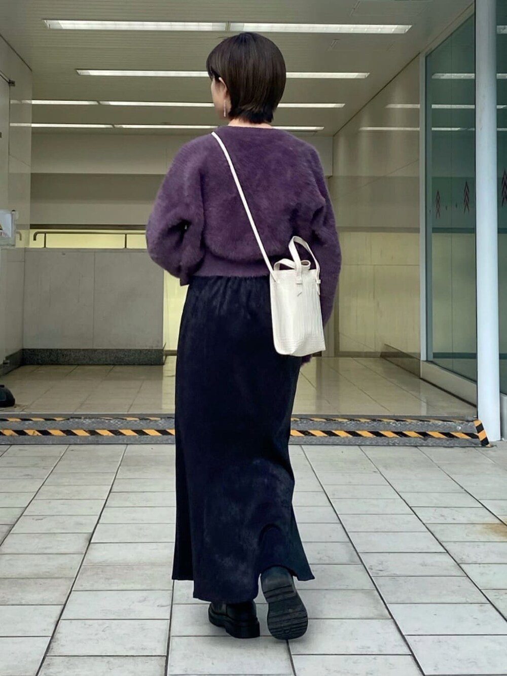 ホワイト系のキャミソール、パープル系のニット/セーター、ブラック系のスカートを着用したレディースの冬コーディネートの3枚目の写真