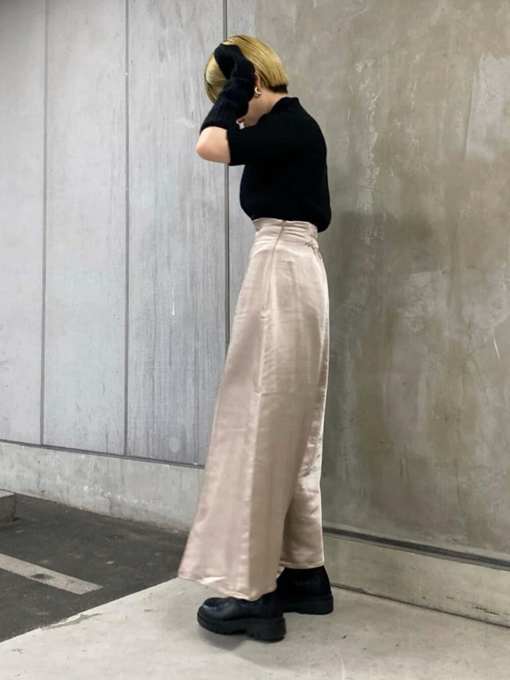 ブラック系のニット/セーター、グレー系のスカート、ブラック系のブーツを着用したレディースの秋コーディネートの2枚目の写真