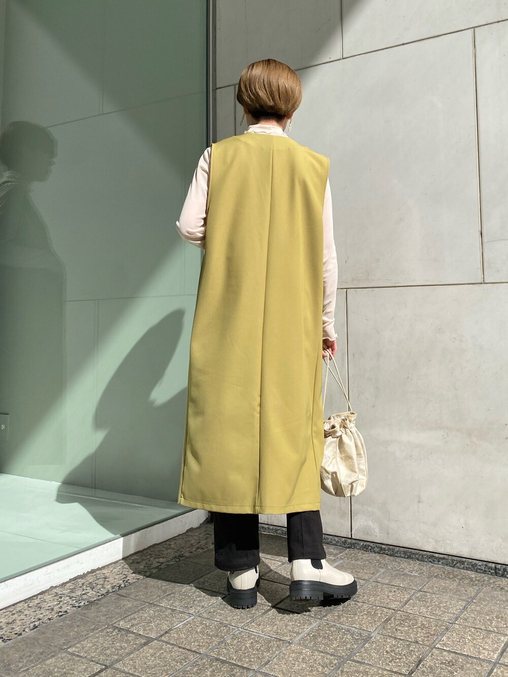 「シンプルコーデ、大人カジュアル、春、今日のコーデ、淡色コーデ、ジレ、ロングジレ、グリーン、春カラー、春コーデ、春服、白ブーツ、巾着バッグ、いいね、save、フォローお願いします🤑」｜「RAY CASSINのジャガード巾着2wayバッグ（バッグ、イエロー系）」を使った、nimoさん（レディース・155cm）の冬コーディネートの4枚目の写真