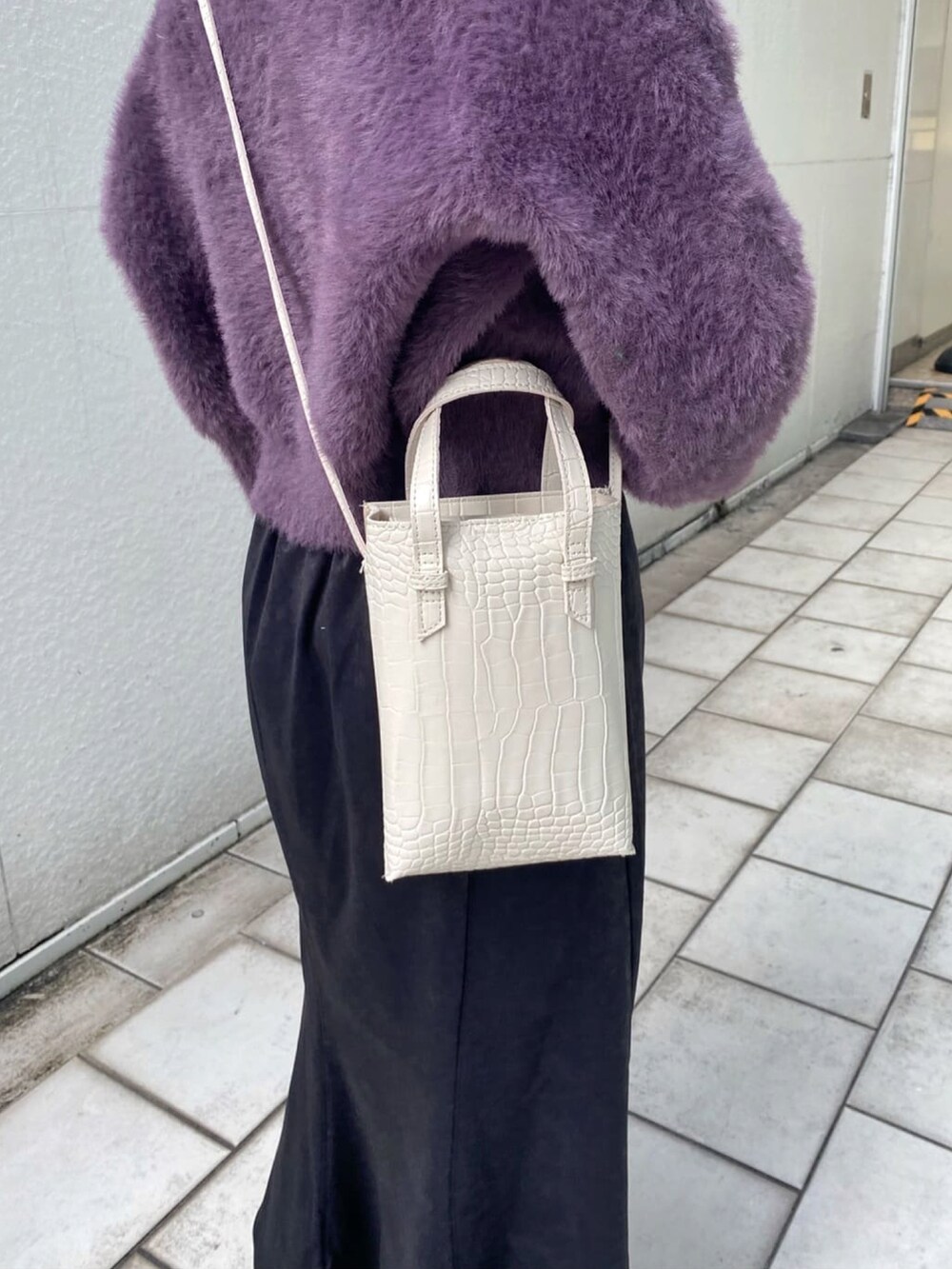 ホワイト系のキャミソール、パープル系のニット/セーター、ブラック系のスカートを着用したレディースの冬コーディネートの5枚目の写真