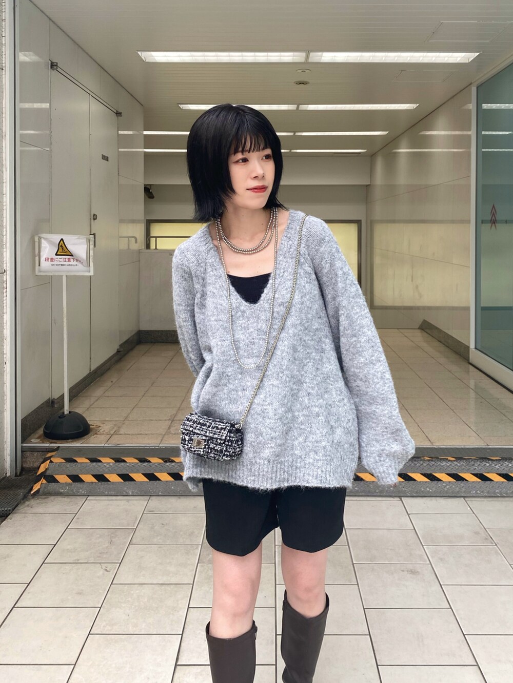 ブラウン系のブーツ、グレー系のニット/セーター、ブラック系のその他パンツを着用したレディースの秋コーディネートの4枚目の写真