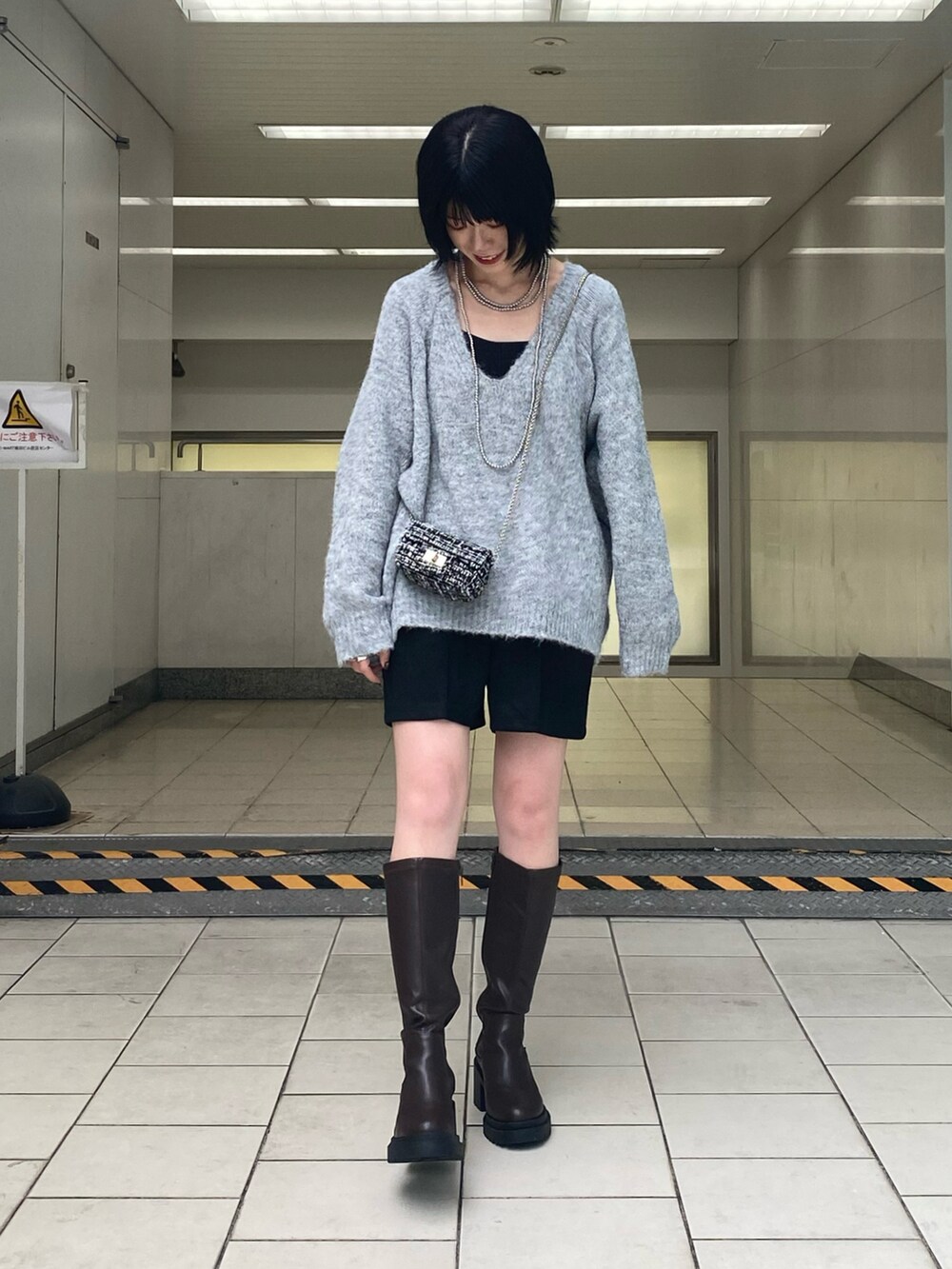 ブラウン系のブーツ、グレー系のニット/セーター、ブラック系のその他パンツを着用したレディースの秋コーディネートの2枚目の写真