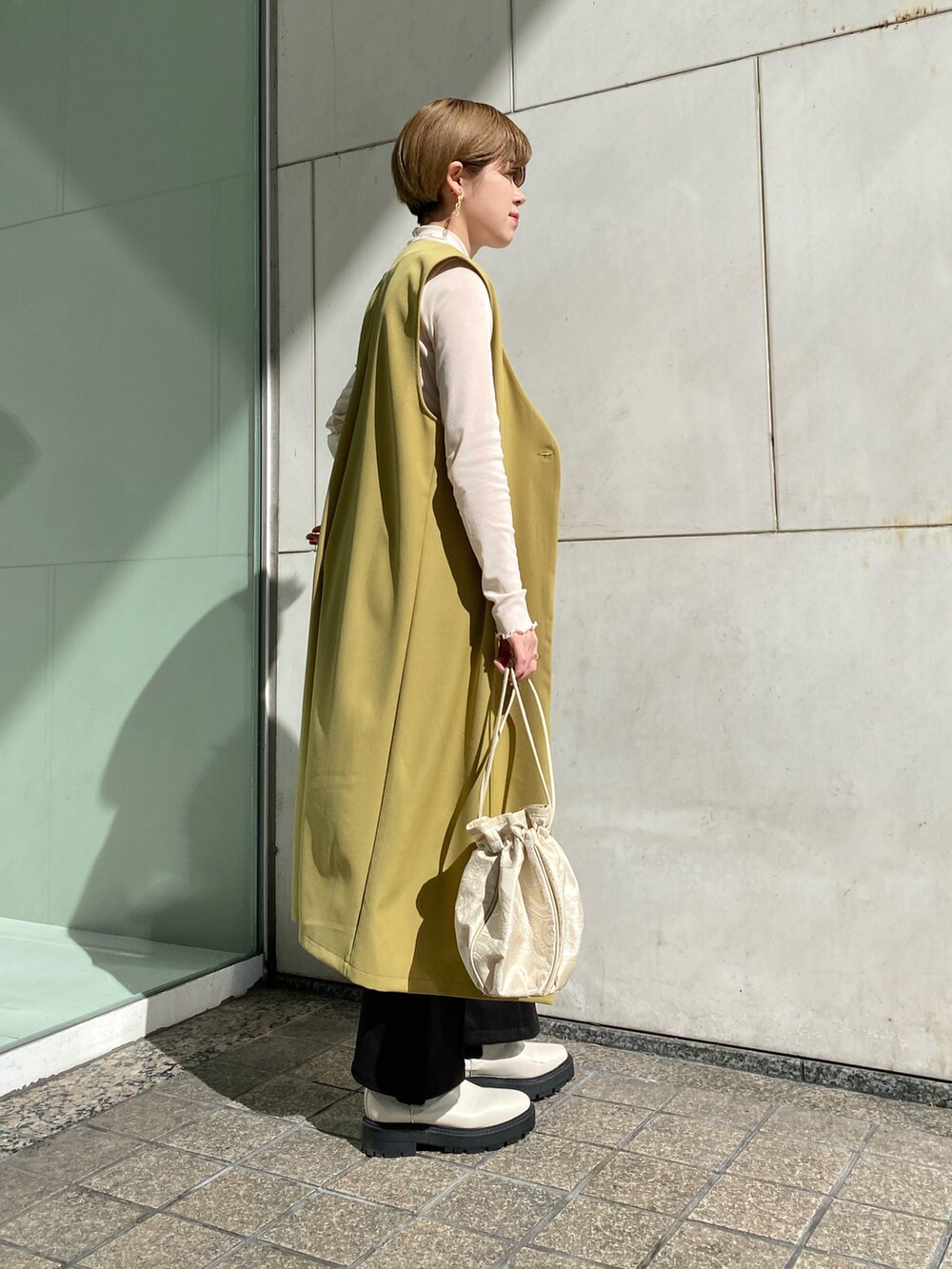 「シンプルコーデ、大人カジュアル、春、今日のコーデ、淡色コーデ、ジレ、ロングジレ、グリーン、春カラー、春コーデ、春服、白ブーツ、巾着バッグ、いいね、save、フォローお願いします🤑」｜「RAY CASSINのジャガード巾着2wayバッグ（バッグ、イエロー系）」を使った、nimoさん（レディース・155cm）の冬コーディネートの3枚目の写真