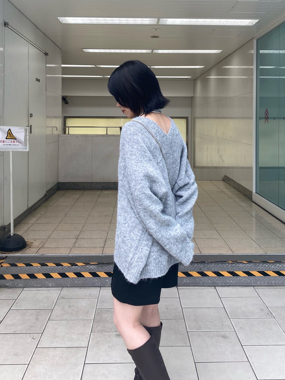 ブラウン系のブーツ、グレー系のニット/セーター、ブラック系のその他パンツを着用したレディースの秋コーディネートの5枚目の写真