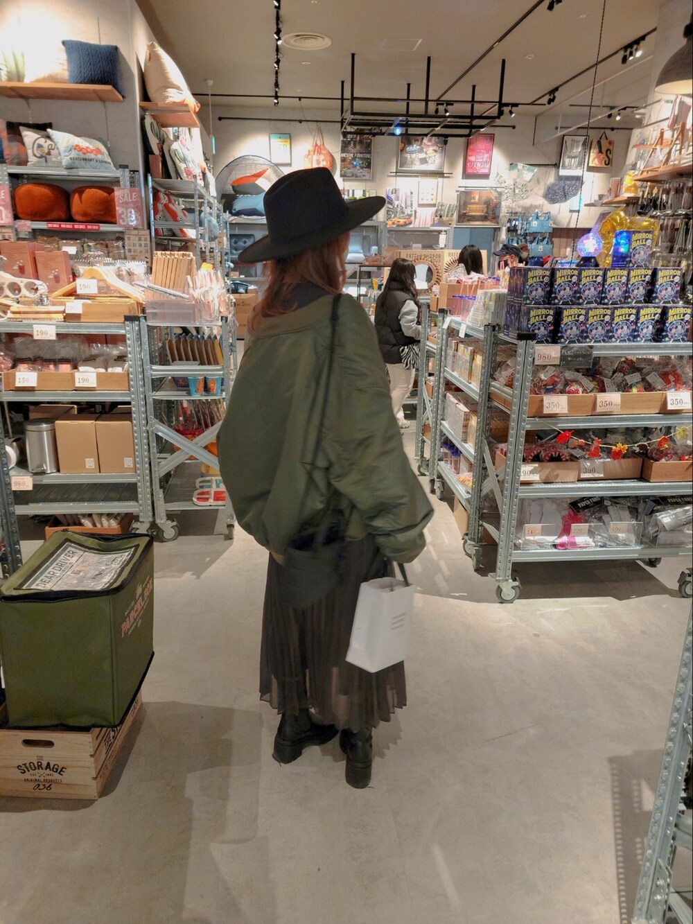 グレー系のスウェット、グレー系のスカート、ブラック系のショルダーバッグを着用したレディースの冬コーディネートの3枚目の写真