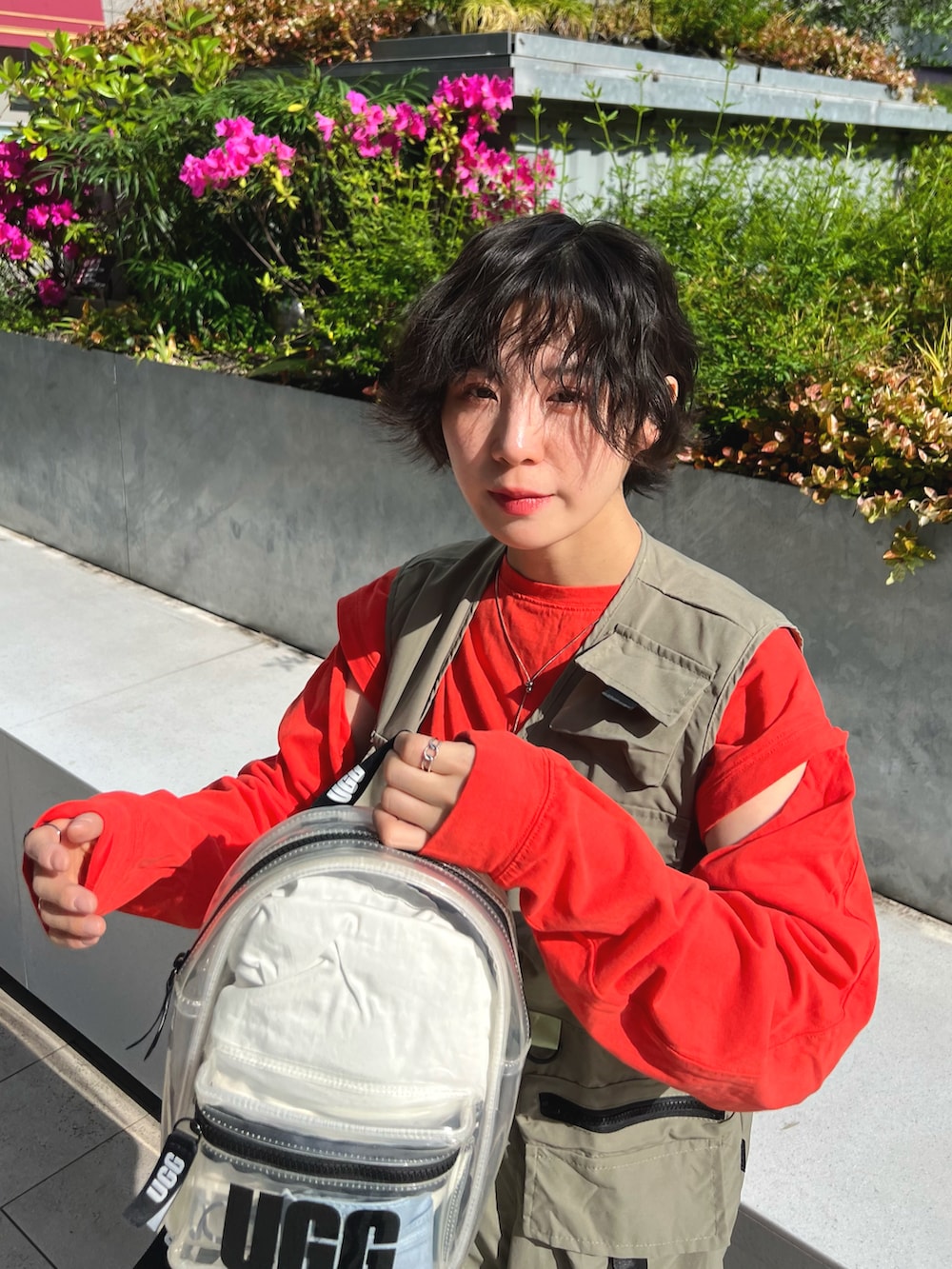 グリーン系のベスト、オレンジ系のTシャツ/カットソー、その他のボディバッグ/ウエストポーチを着用したレディースの春コーディネートの2枚目の写真