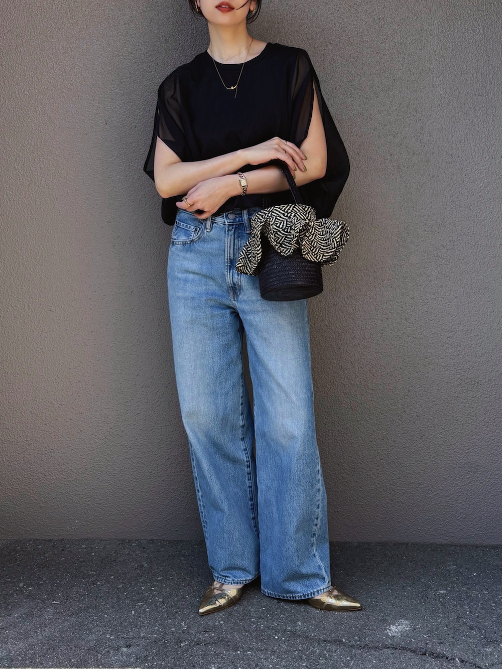 ブラック系のシャツ/ブラウス、ブルー系のデニムパンツ、ゴールド系のパンプスを着用したレディースの春コーディネートの3枚目の写真