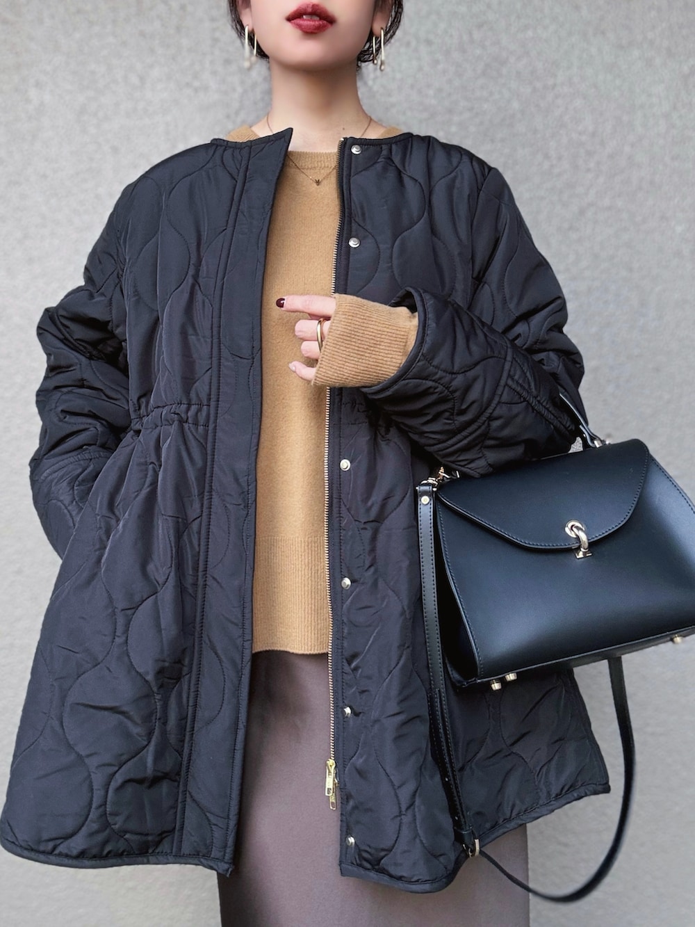 ブラック系のその他アウター、イエロー系のニット/セーター、ブラウン系のスカートを着用したレディースの秋コーディネートの2枚目の写真