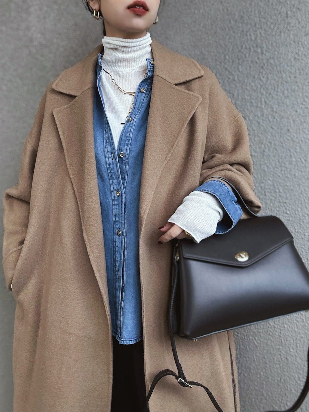 ブルー系のシャツ/ブラウス、ホワイト系のニット/セーター、ブラック系のスラックスを着用したレディースの冬コーディネートの3枚目の写真