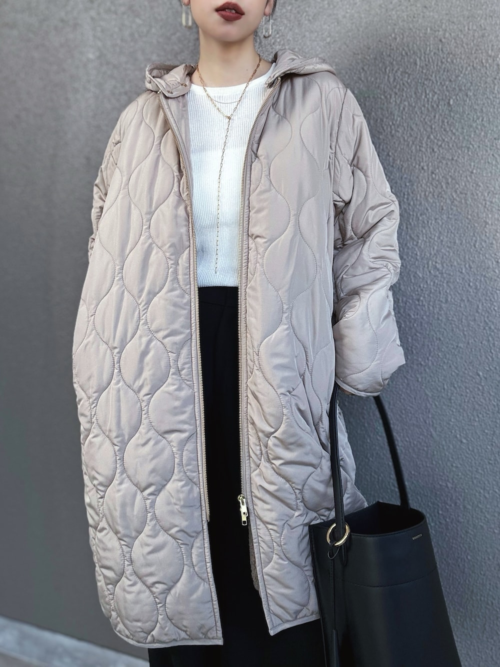 ブラウン系のその他アウター、ホワイト系のニット/セーター、ブラウン系のローファーを着用したレディースの冬コーディネートの3枚目の写真