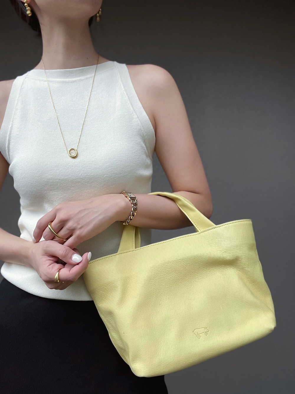 ブラック系のスカート、ホワイト系のタンクトップ、ブラック系のサンダルを着用したレディースの夏コーディネートの3枚目の写真