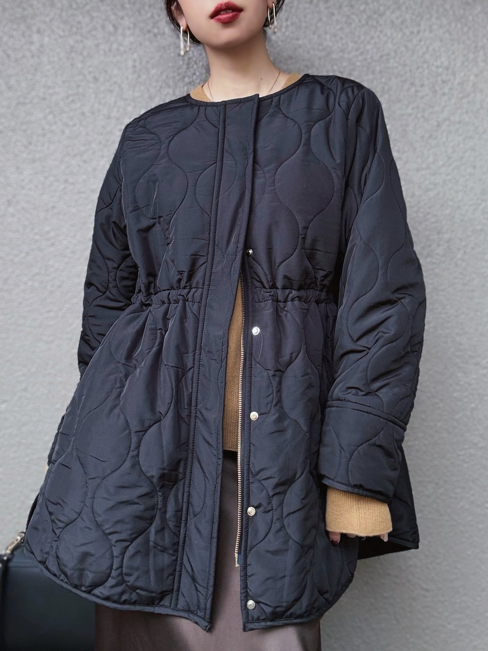 ブラック系のその他アウター、イエロー系のニット/セーター、ブラウン系のスカートを着用したレディースの秋コーディネートの3枚目の写真