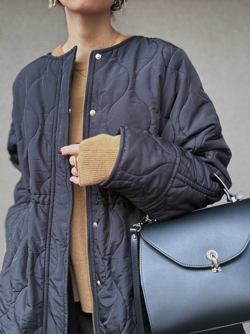 ブラック系のその他アウター、イエロー系のニット/セーター、ブラウン系のスカートを着用したレディースの秋コーディネートの4枚目の写真