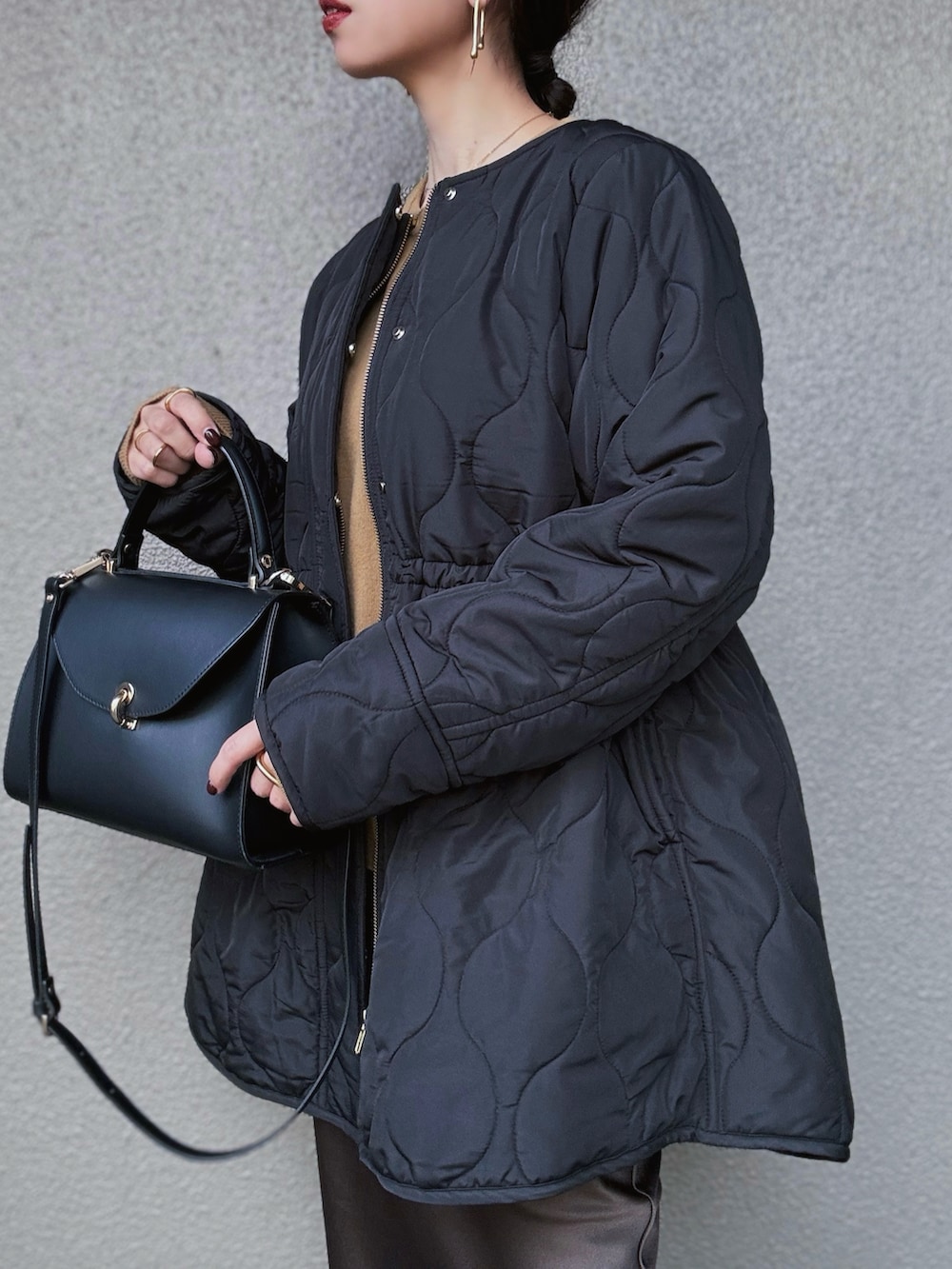 ブラック系のその他アウター、イエロー系のニット/セーター、ブラウン系のスカートを着用したレディースの秋コーディネートの5枚目の写真