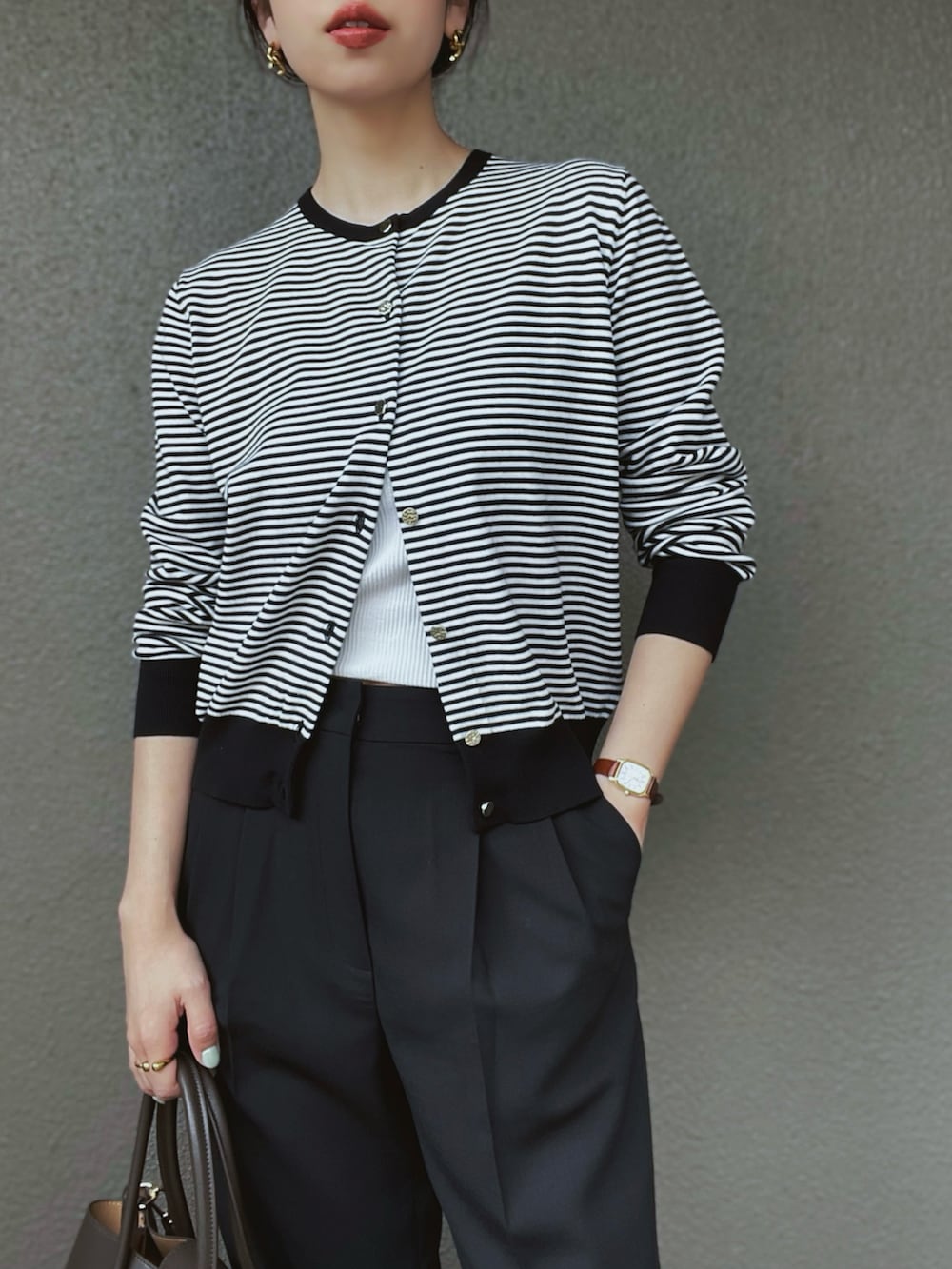 ホワイト系のカーディガン/ボレロ、ブラック系のスラックス、ホワイト系のキャミソールを着用したレディースの春コーディネートの2枚目の写真