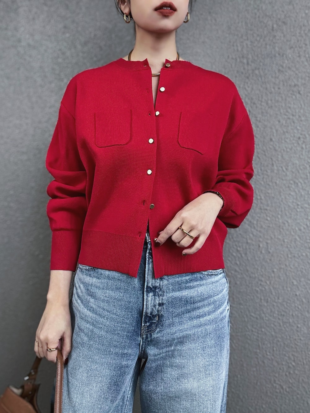 レッド系のカーディガン/ボレロ、シルバー系のパンプス、ブルー系のデニムパンツを着用したレディースの冬コーディネートの2枚目の写真