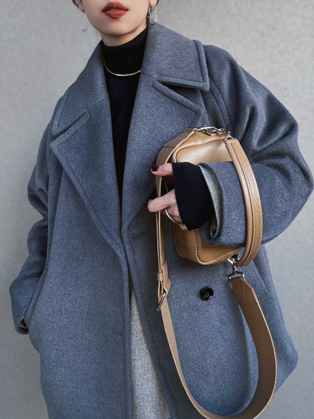 グレー系のピーコート、ベージュ系のシャツ/ブラウス、ブラック系のニット/セーターを着用したレディースの冬コーディネートの3枚目の写真