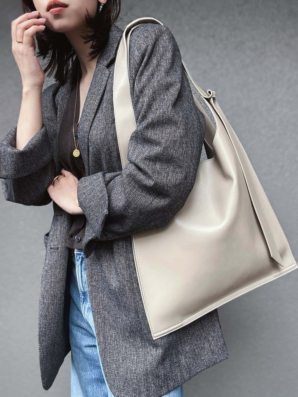 ブラウン系のニット/セーター、ブラウン系のテーラードジャケット、イエロー系のパンプスを着用したレディースの秋コーディネートの2枚目の写真