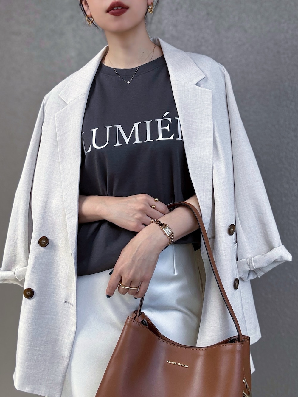 ブラック系のTシャツ/カットソー、ホワイト系のテーラードジャケット、ホワイト系のスカートを着用したレディースの夏コーディネートの2枚目の写真