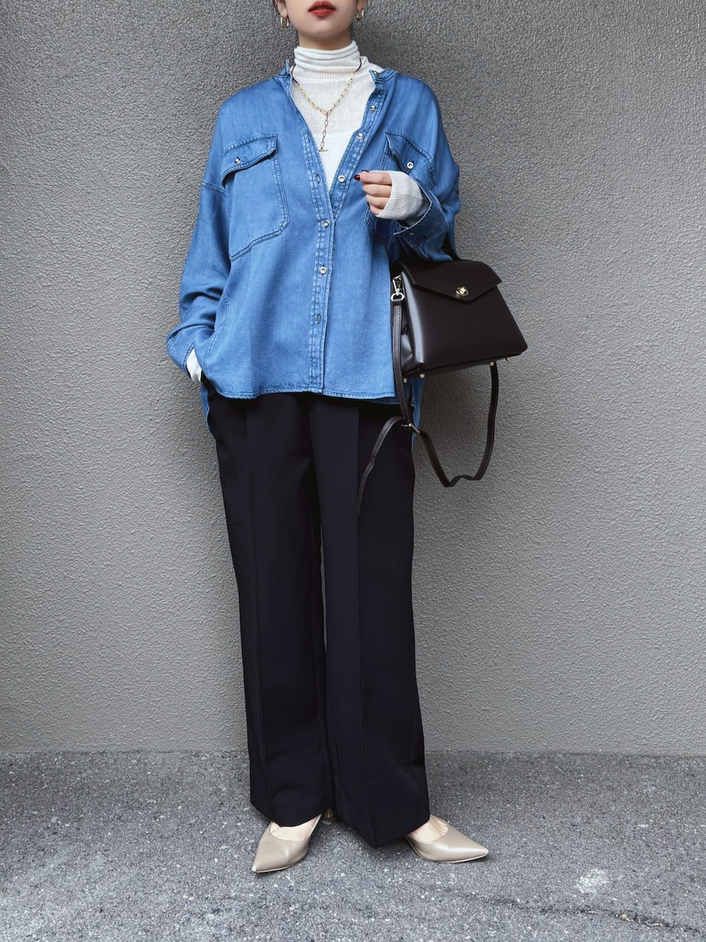 ブルー系のシャツ/ブラウス、ホワイト系のニット/セーター、ブラック系のスラックスを着用したレディースの冬コーディネートの4枚目の写真