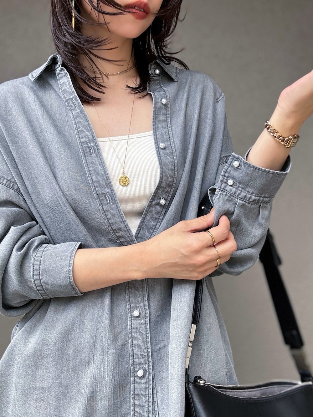 ホワイト系のキャミソール、ブラック系のスカート、ブラック系のショルダーバッグを着用したレディースの秋コーディネートの3枚目の写真