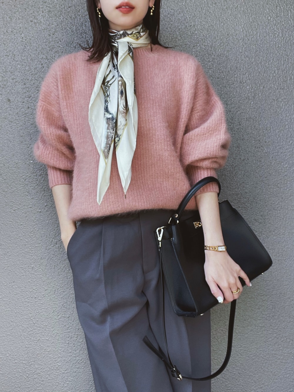 ピンク系のニット/セーター、グレー系のその他パンツ、ブラック系のパンプスを着用したレディースの秋コーディネートの2枚目の写真