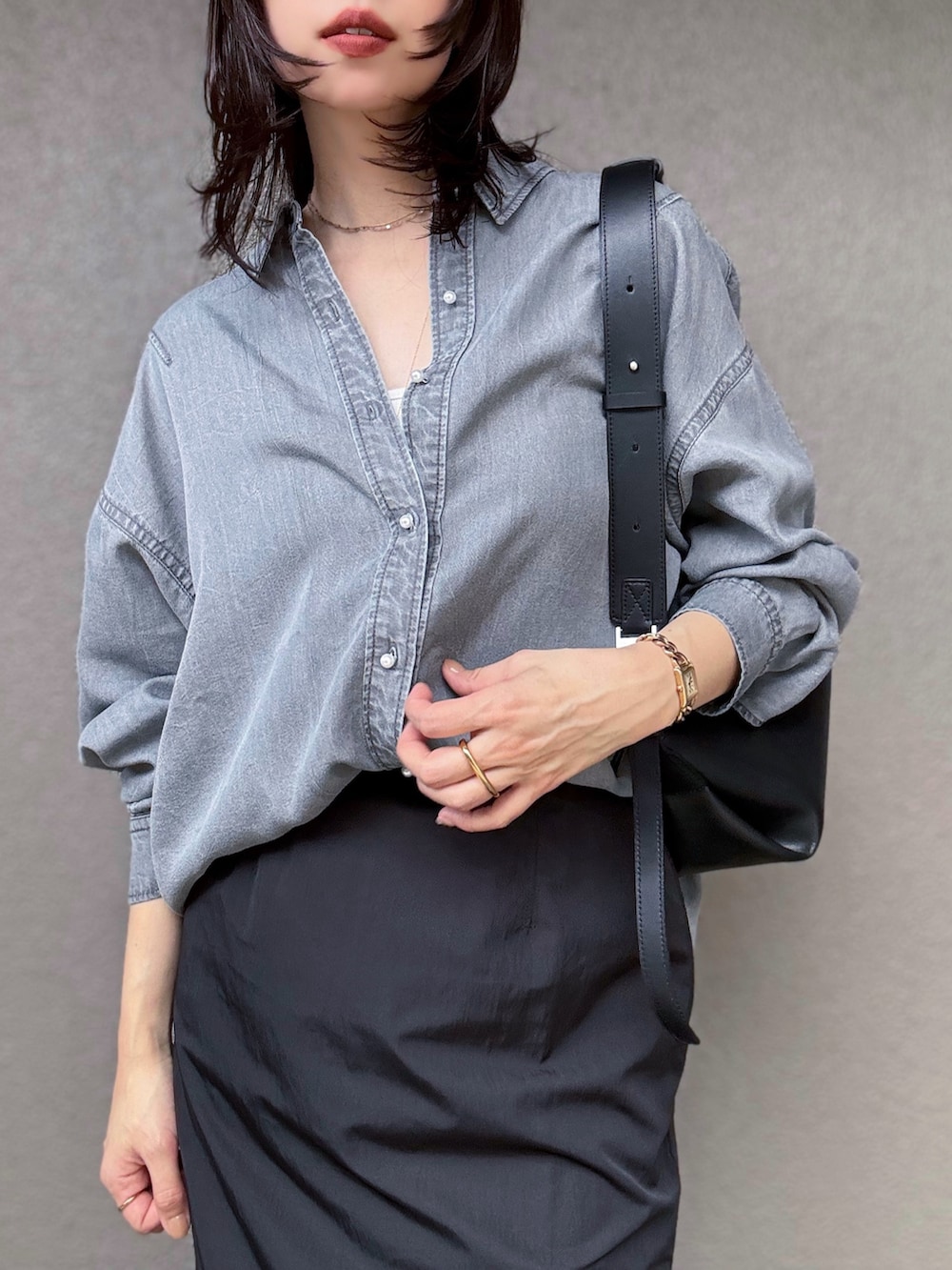 ホワイト系のキャミソール、ブラック系のスカート、ブラック系のショルダーバッグを着用したレディースの秋コーディネートの4枚目の写真