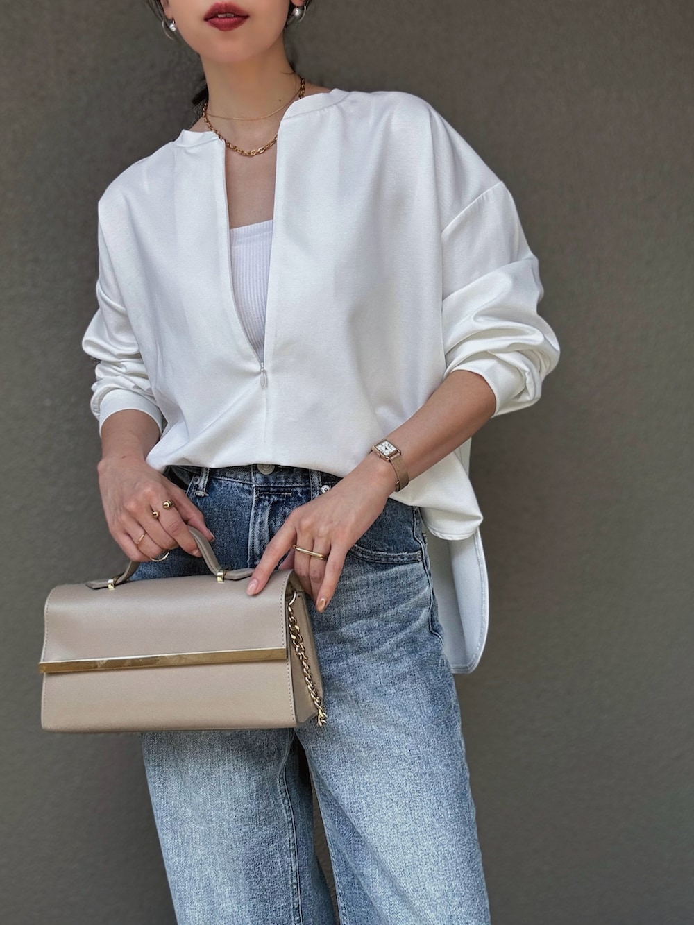 ホワイト系のTシャツ/カットソー、ブルー系のデニムパンツ、ベージュ系のパンプスを着用したレディースの秋コーディネートの2枚目の写真