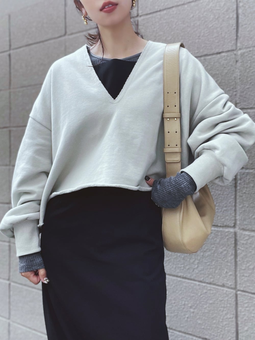 ベージュ系のスウェット、ブラック系のワンピース、グレー系のニット/セーターを着用したレディースの秋コーディネートの3枚目の写真