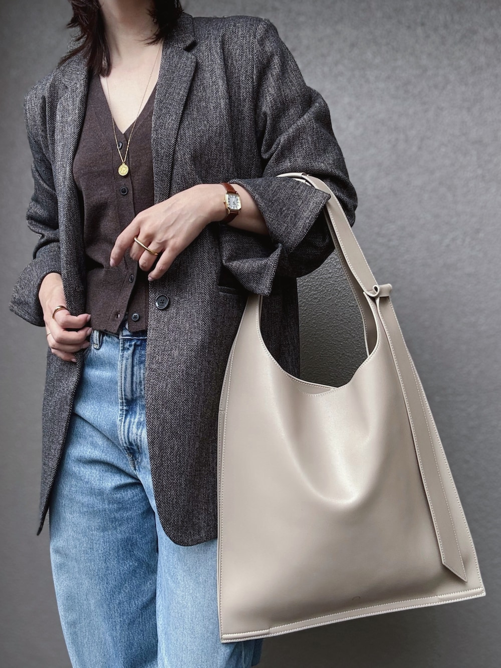 ブラウン系のニット/セーター、ブラウン系のテーラードジャケット、イエロー系のパンプスを着用したレディースの秋コーディネートの3枚目の写真