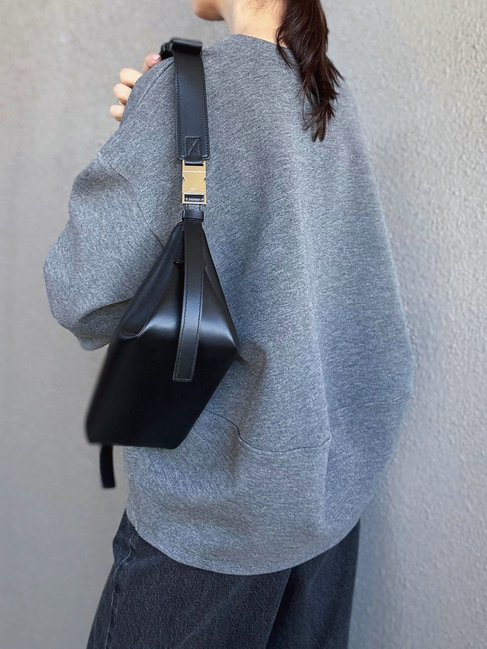 グレー系のTシャツ/カットソー、ブラック系のショルダーバッグ、ホワイト系のTシャツ/カットソーを着用したレディースの秋コーディネートの4枚目の写真