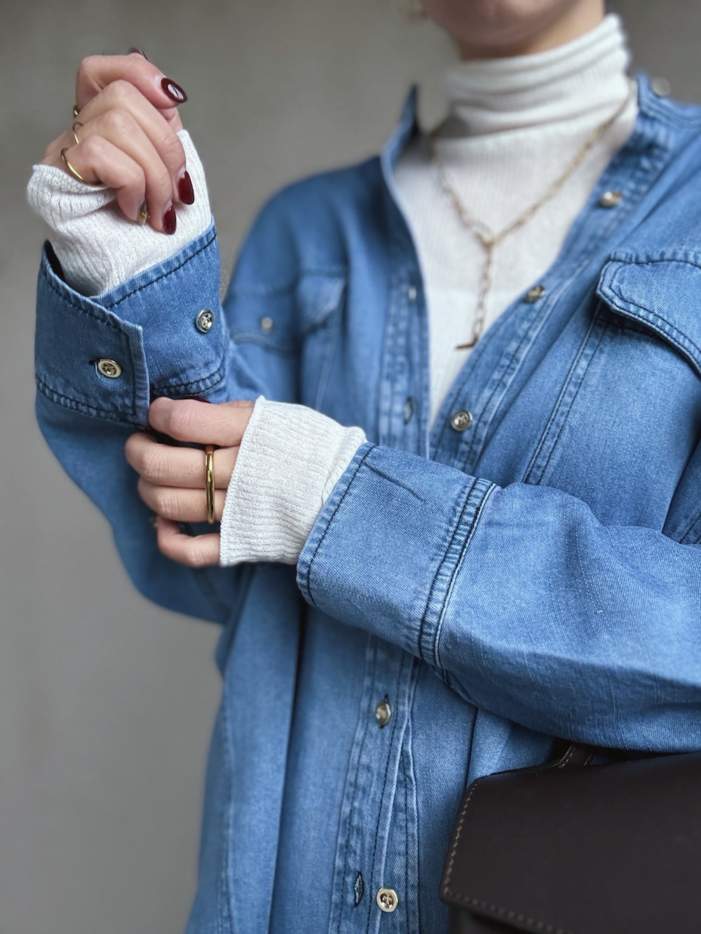 ブルー系のシャツ/ブラウス、ホワイト系のニット/セーター、ブラック系のスラックスを着用したレディースの冬コーディネートの5枚目の写真