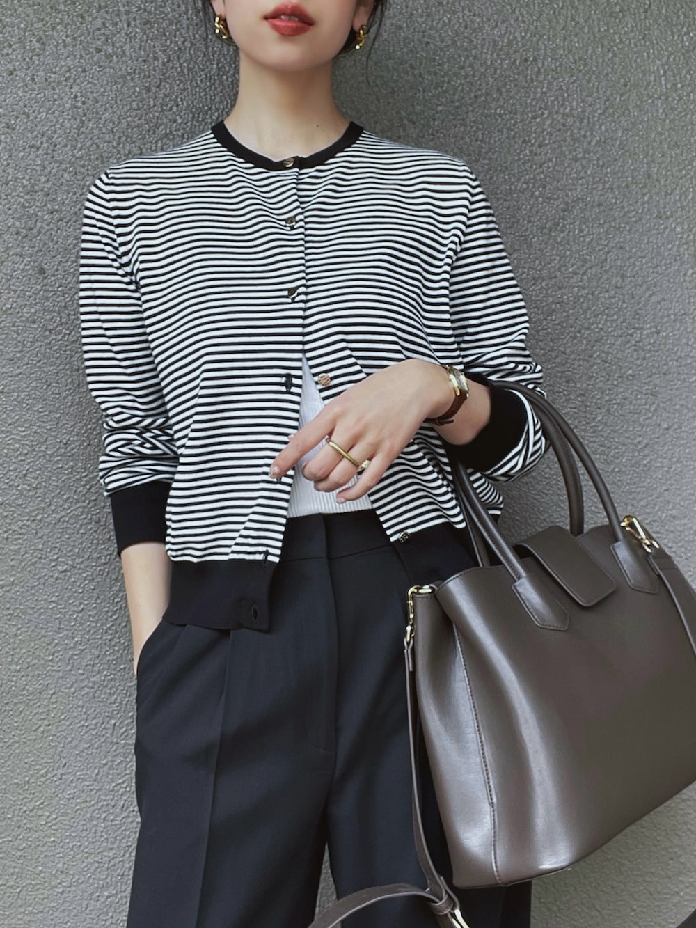 ホワイト系のカーディガン/ボレロ、ブラック系のスラックス、ホワイト系のキャミソールを着用したレディースの春コーディネートの3枚目の写真