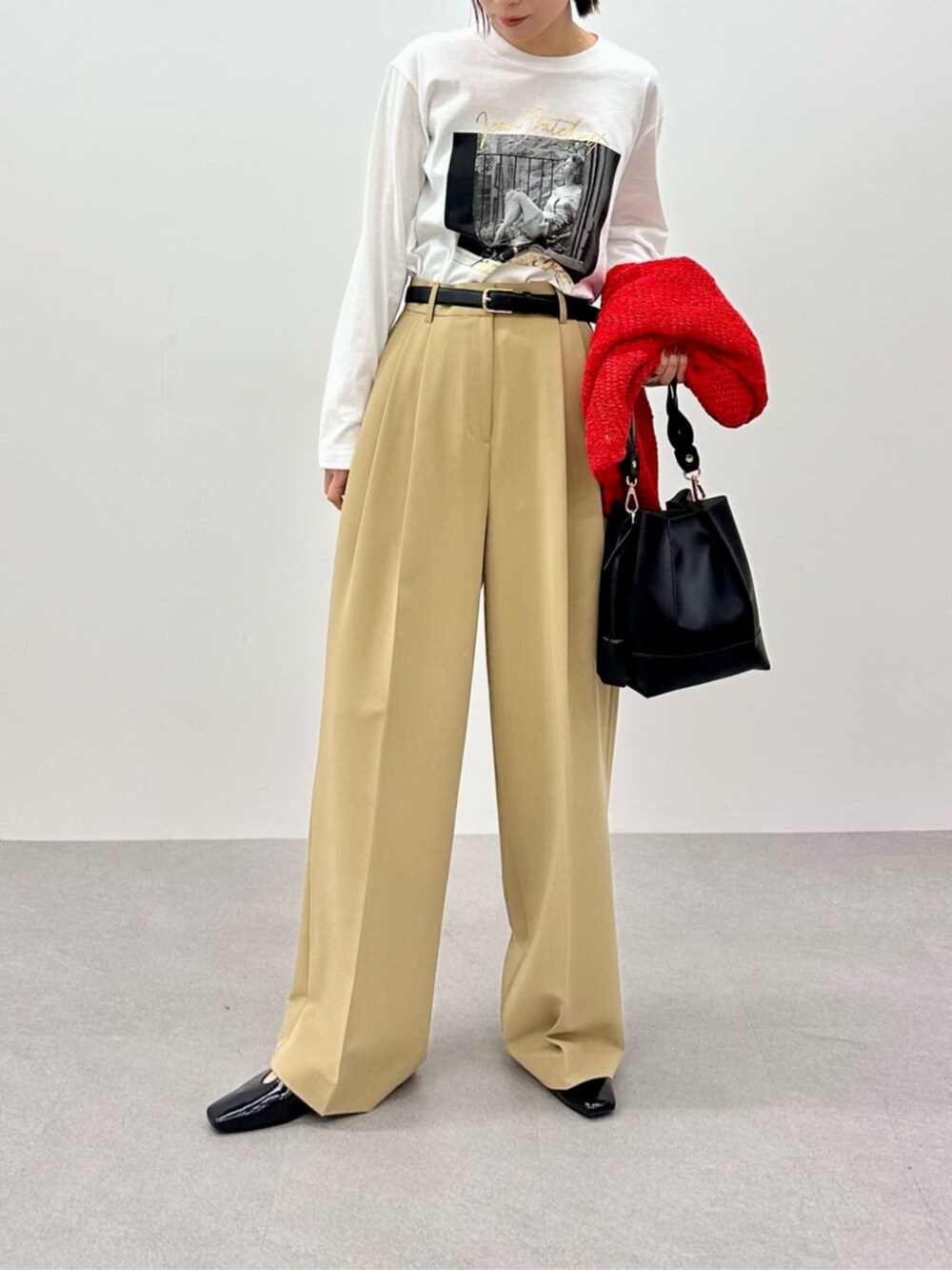 レッド系のニット/セーター、ホワイト系のTシャツ/カットソー、ベージュ系のその他パンツを着用したレディースの春コーディネートの6枚目の写真