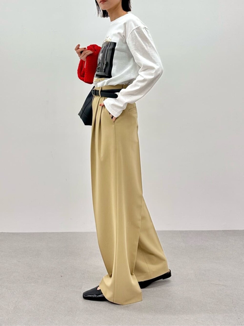 レッド系のニット/セーター、ホワイト系のTシャツ/カットソー、ベージュ系のその他パンツを着用したレディースの春コーディネートの8枚目の写真