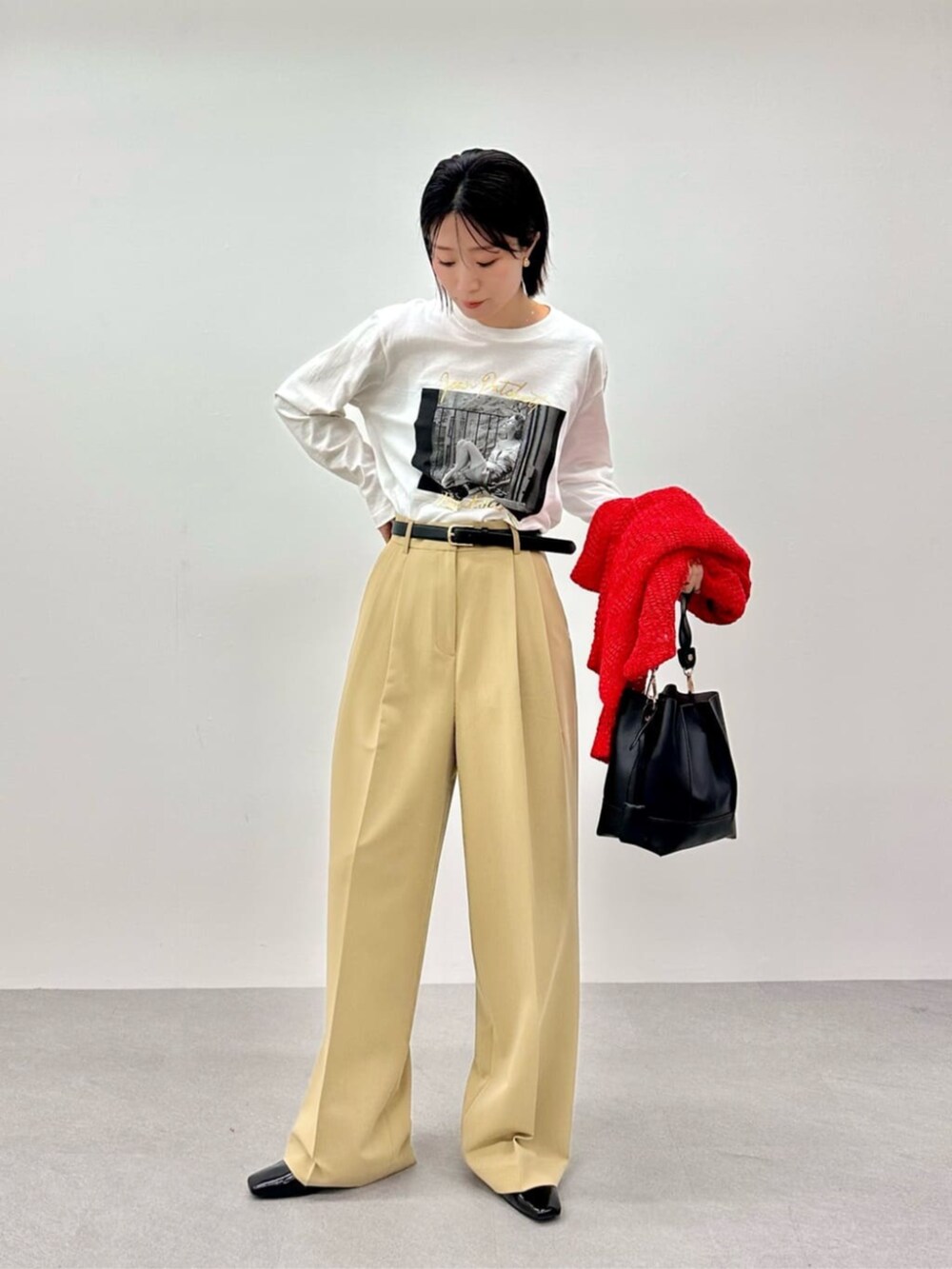 レッド系のニット/セーター、ホワイト系のTシャツ/カットソー、ベージュ系のその他パンツを着用したレディースの春コーディネートの5枚目の写真
