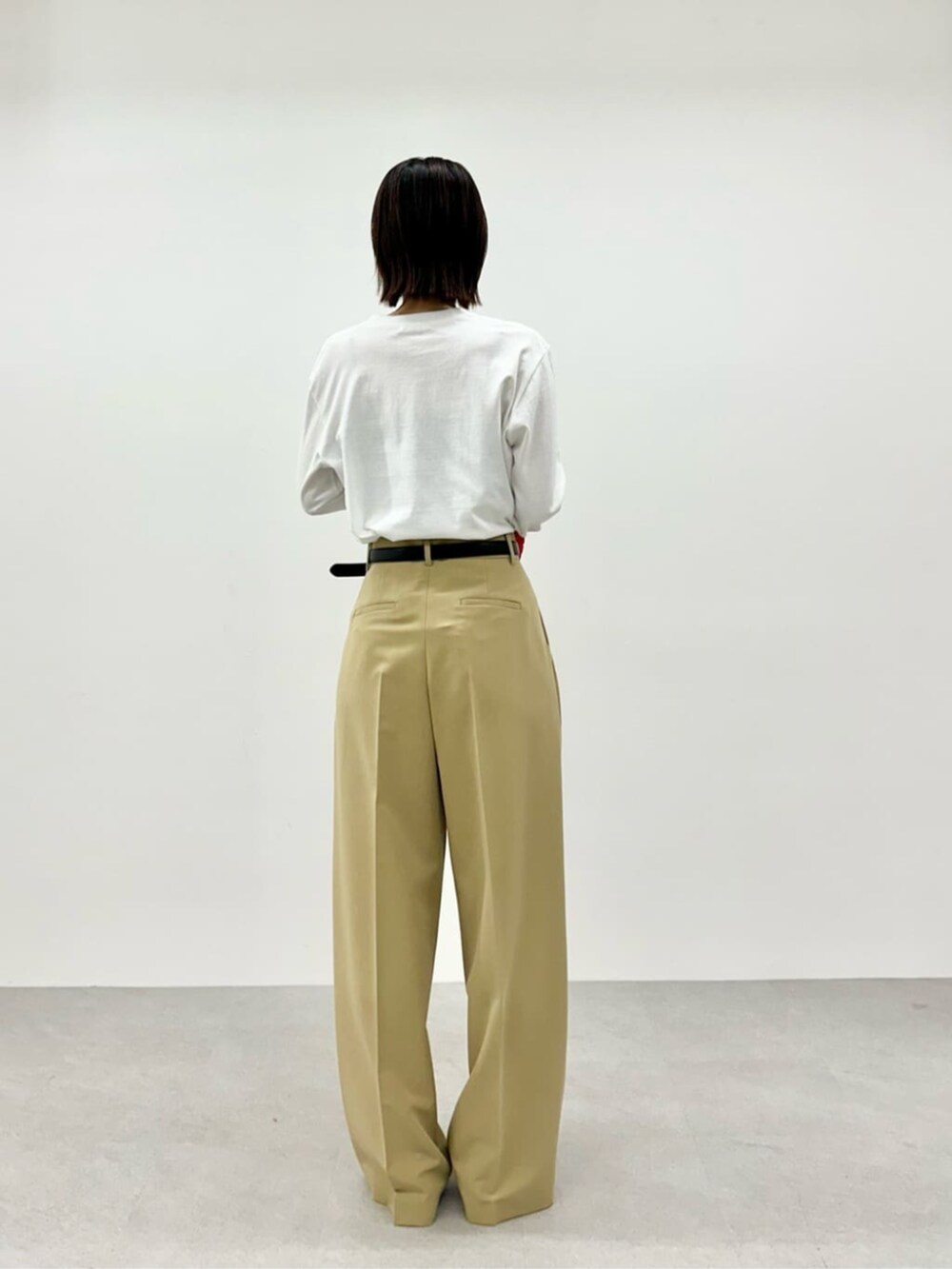 レッド系のニット/セーター、ホワイト系のTシャツ/カットソー、ベージュ系のその他パンツを着用したレディースの春コーディネートの7枚目の写真