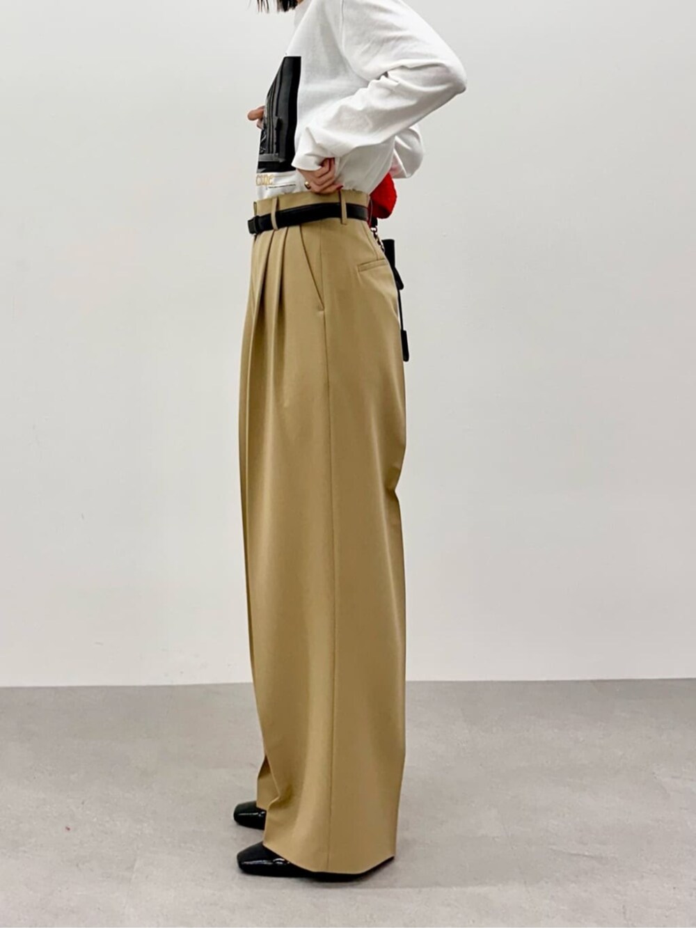 レッド系のニット/セーター、ホワイト系のTシャツ/カットソー、ベージュ系のその他パンツを着用したレディースの春コーディネートの9枚目の写真