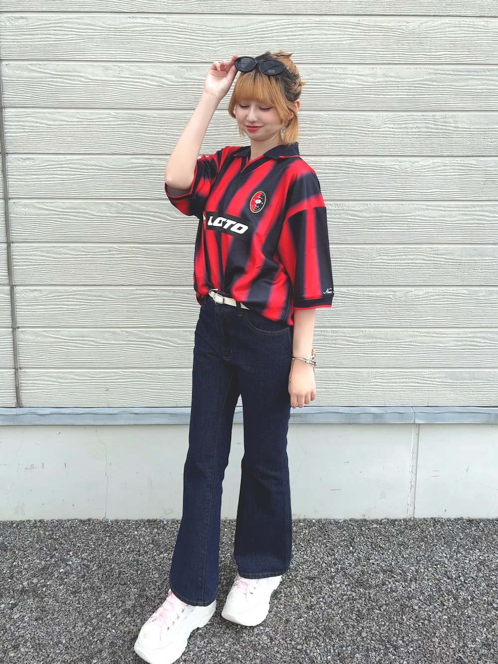 ブルー系のデニムパンツ、レッド系のTシャツ/カットソー、ホワイト系のベルトを着用したレディースの春コーディネートの2枚目の写真